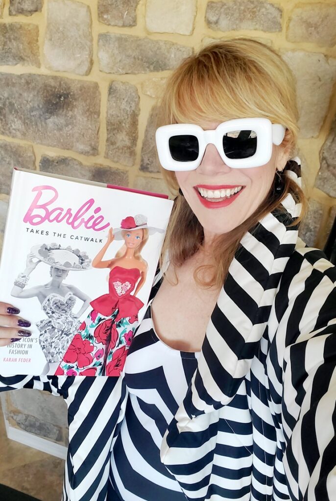 Stacey Gualandi and her Barbie look, holding the Barbie takes the Catwalk book by Karan Feder/Photo Courtesy Stacey Gualandi