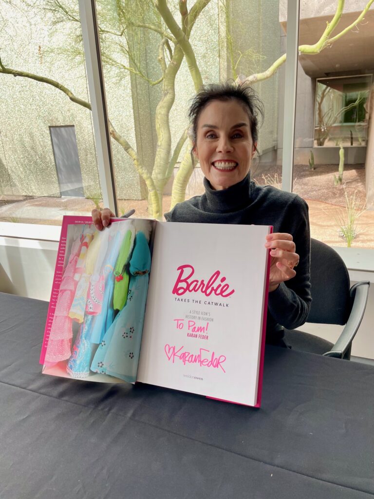 Author Karan Feder holding her Barbie Takes the Catwalk book at the Phoenix Art Museum during their exhibit/Photo: P. Burke
